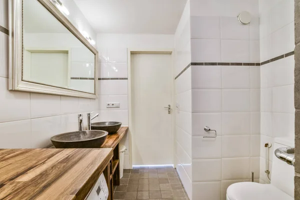 a bathroom with a sink, toilet and wooden counter in the corners on the left side of the room