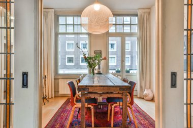 Masalı bir yemek odası, sandalyeler ve kapının önünde bir halı.