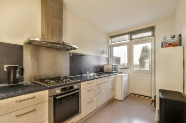 Mutfak ocağı, lavabo ve bulaşık makinesi tezgahın üstünde pencerenin önünde açık.