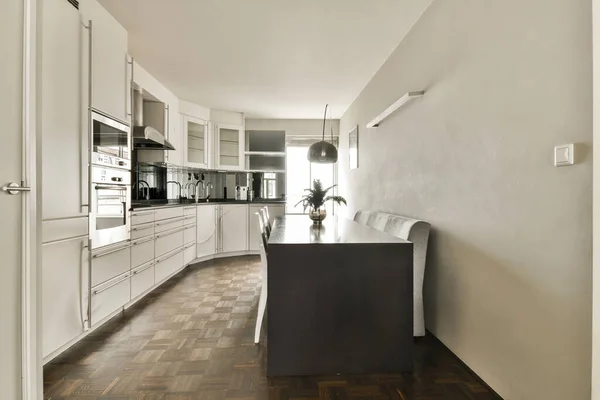 Eine Küche Mit Holzboden Und Weißen Schränken Hinteren Teil Entlang — Stockfoto
