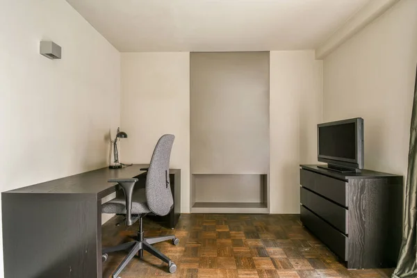 Ein Kleines Zimmer Mit Schreibtisch Stuhl Und Fernseher Der Ecke — Stockfoto