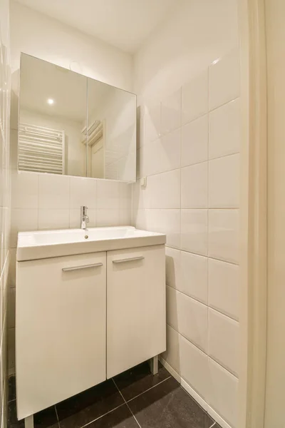 Duvarlarında Beyaz Fayanslar Olan Bir Banyo Lavabonun Önündeki Siyah Döşeme — Stok fotoğraf
