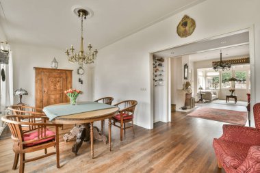 Sandalyeli bir yemek odası ve açık oturma odasına açılan kapının önünde bir masa.