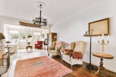 Oturma odasında yerde bir halı ve odanın ortasında da sağ tarafta bir halı var.