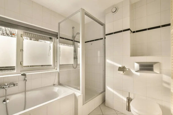 Een Badkamer Met Witte Tegels Zwarte Bekleding Rond Het Bad — Stockfoto