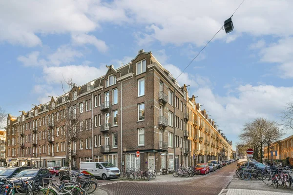 stock image a street with many bikes parked in front of the building and cars parked on the other side of the street