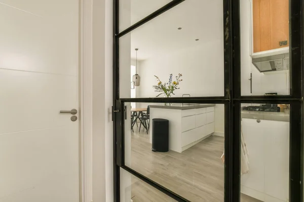 白い壁 木の床と木製の床とオープンリビングルームへのガラスドアを通ってキッチンとダイニングエリア — ストック写真