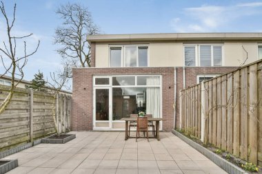 İlk kez kullanılmak üzere inşa edilmiş bir evin önünde masa ve sandalyeli bir teras.