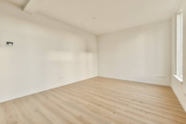 Odanın her iki tarafında beyaz duvarları ve ahşap döşemeleri olan boş bir oda var.