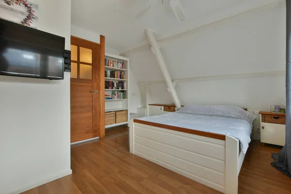 Sypialnia Drewnianą Podłogą Telewizor Zamontowany Ścianie Nad Łóżkiem Przed Łóżkiem — Zdjęcie stockowe