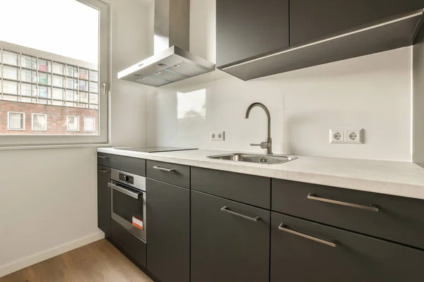 Una Zona Cocina Con Armarios Negros Encimeras Blancas Apartamento Tomada — Foto de Stock