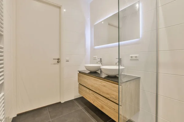 旁边墙上有水池和镜子的浴室是一个毛巾架 放置在浴室前面 — 图库照片