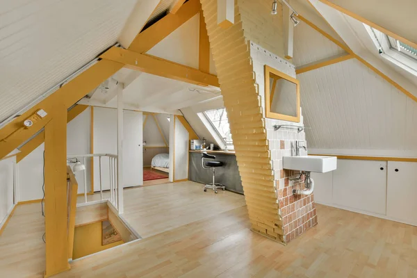 一间有木地板和白墙的客厅 通往二楼的敞开的楼梯清晰可见 — 图库照片