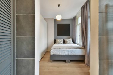 Ortasında yatak odası olan bir yatak odası ve diğer taraftaki başka bir odaya açılan bir kapı.