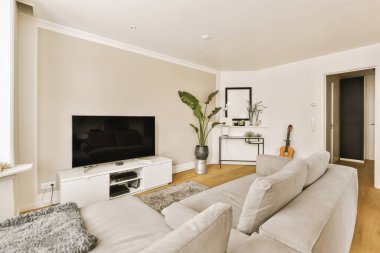 İki koltuklu bir oturma odası ve odanın ortasındaki duvarda büyük bir düz ekran televizyon.