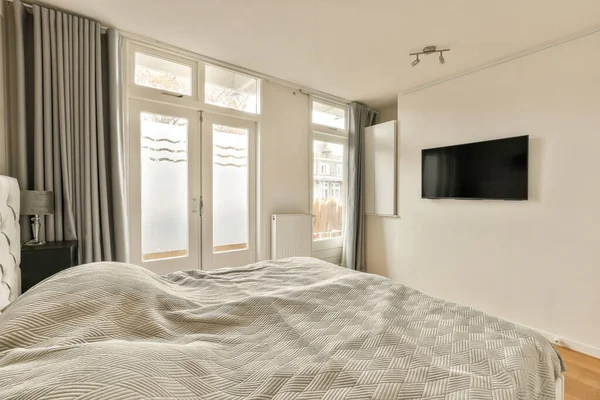 stock image a bedroom with a tv on the wall and a bed in front of a sliding glass door that leads to an outside patio