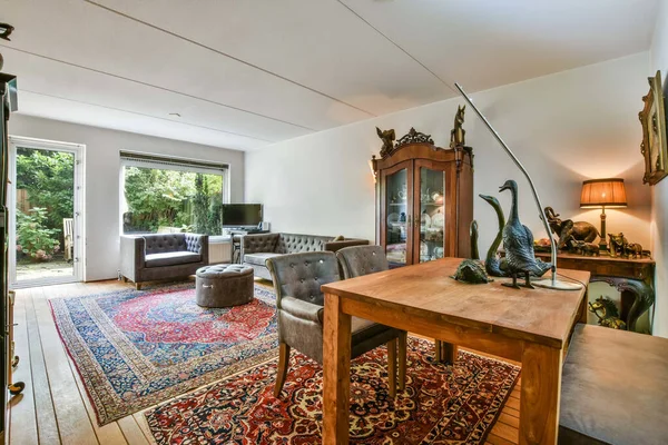 stock image a living room with an oriental rug on the floor and a large wooden table in the room is surrounded by trees