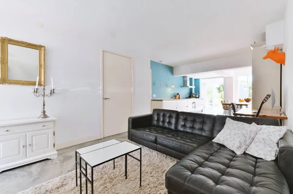 ソファの前の床に黒い革のソファと白いラグのあるリビングルームはコーヒーテーブルです — ストック写真
