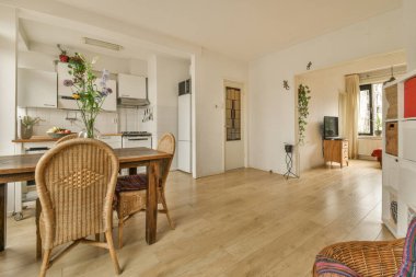 Ahşap zemin, beyaz duvarlar ve ahşap döşeme olan bir evde mutfak ve yemek odası çok temiz.