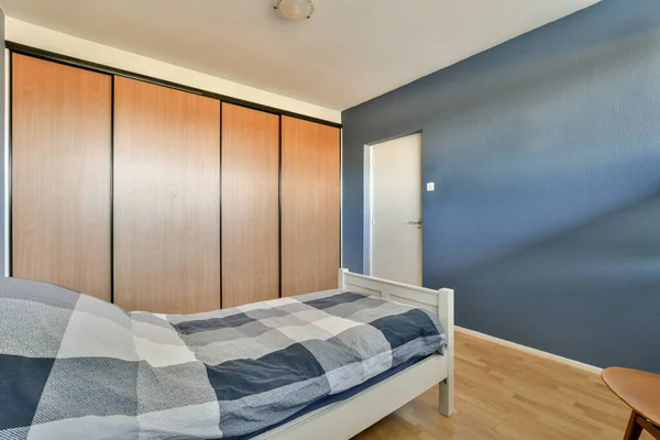 Sypialnia Niebieskimi Ścianami Drewnianą Podłogą Tym Łóżko Które Wygląda Jak — Zdjęcie stockowe