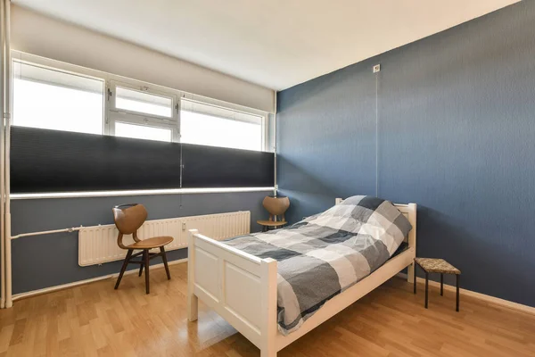 Sypialnia Niebieskimi Ścianami Drewnianą Podłogą Ścianie Pokoju Znajduje Się Łóżko — Zdjęcie stockowe
