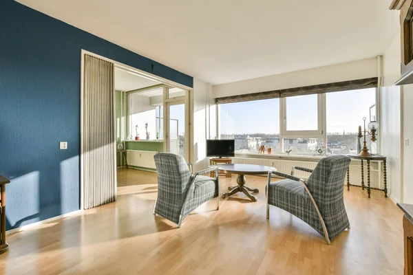 Salon Niebieskimi Ścianami Drewnianą Podłogą Dwa Krzesła Skierowane Okno Widokiem — Zdjęcie stockowe
