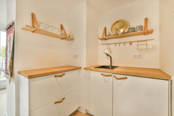 Dapur Dengan Lemari Putih Dan Rak Kayu Dinding Belakangnya Adalah — Stok Foto