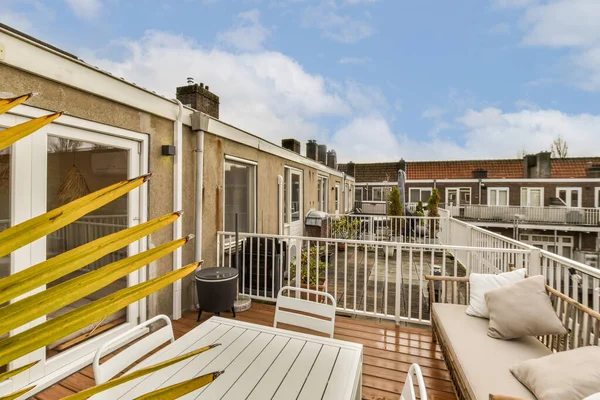 stock image a balcony with white furniture and blue sky in the background, taken from an outdoor living room on a sunny day