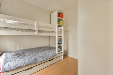 Ranzalı küçük bir oda ve başka bir odaya açılan açık bir kapının önünde bir yatak.