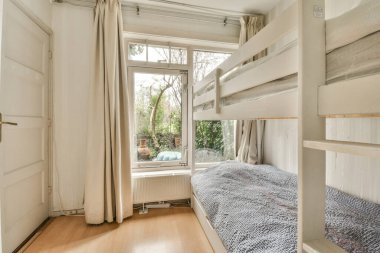 Ranzalı küçük bir oda ve apartmanın önündeki sokağa bakan bir pencere.
