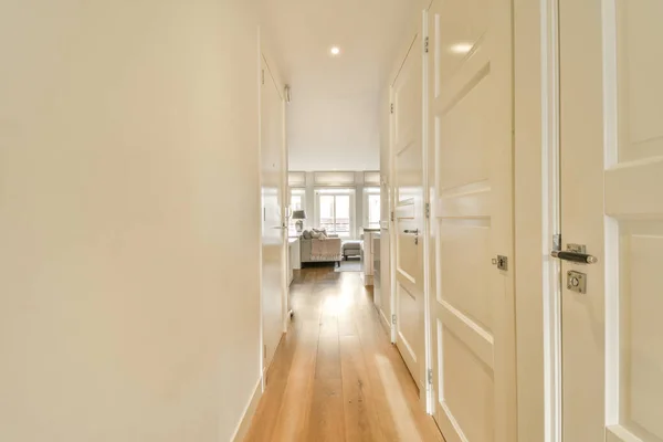 一条长长的走廊 两边都有白色的墙壁和木地板 通向客厅 — 图库照片