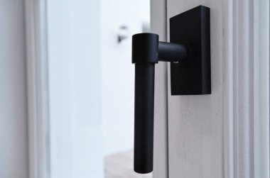 Fotoğrafta açık penceresi olan beyaz bir binanın kapı kolu bulanık ve bulanıktır.