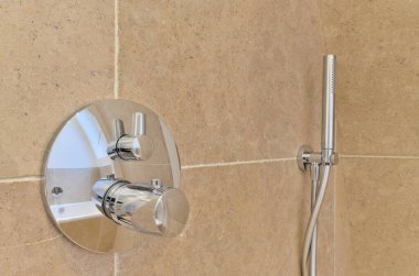 Duş başlığı ve eli duvara monte edilmiş sabun kutusuna bağlı bir banyo ayarı.