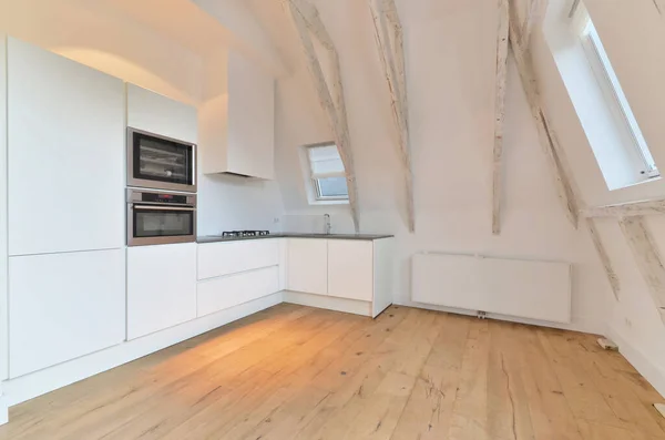 Eine Küche Mit Holzboden Und Weißen Schränken Der Wand Einer — Stockfoto