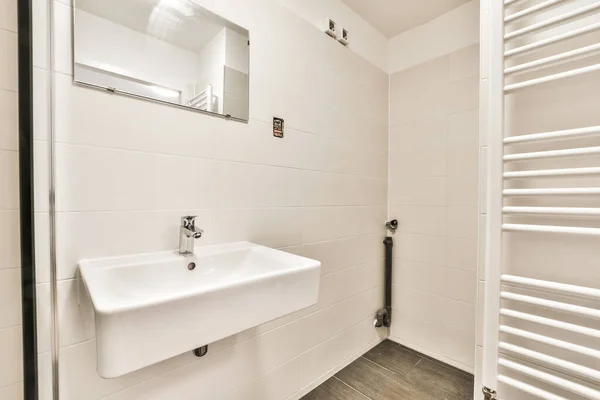 Łazienka Umywalką Wieszakiem Ręczniki Ścianie Obok Radu Pustym Białym Pokoju — Zdjęcie stockowe