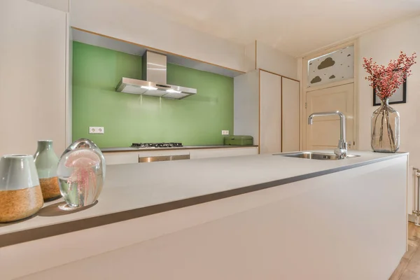 Eine Küche Mit Weißen Arbeitsplatten Und Grünen Wänden Der Rückwand — Stockfoto