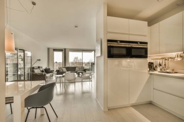 Modern bir dairede mutfak ve yemek odası diğer taraftaki oturma odasına kadar açık bir zemin.