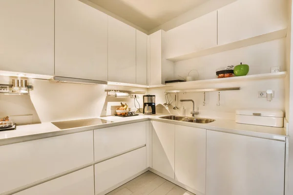 a small kitchen with white cupboards and appliances on the counter top in this photo is taken from the inside