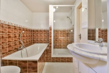 Küveti, tuvaleti ve küveti olan bir banyo fayanslı duvarda görünen renkle aynı.