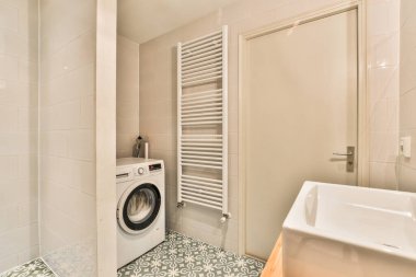 Çamaşır odası. Çamaşır makinesi ve kurutma makinesi. Tuvalet eşyalarının yanında.