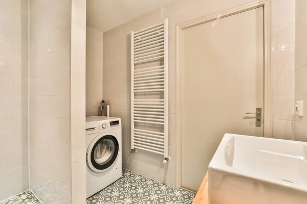 洗面所のドアの前に洗濯乾燥機付きのランドリールームがあります — ストック写真