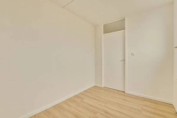 白い壁と木の床のある空いている部屋の右側にドアが開いています — ストック写真