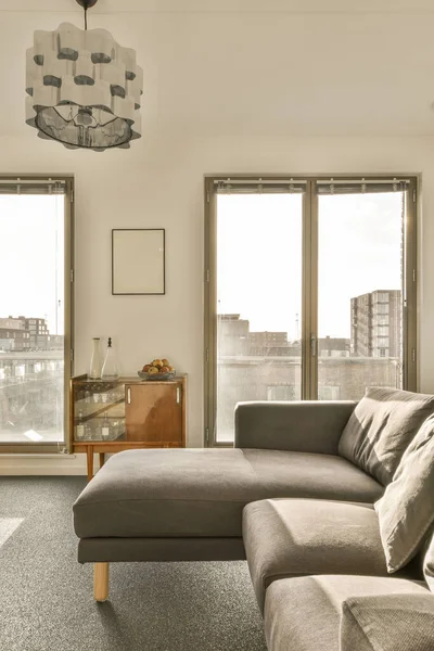 Ett Vardagsrum Med Två Fönster Och Stor Soffa Framför Fönstret — Stockfoto