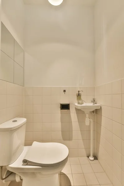 Łazienka Białą Płytką Beżowymi Płytkami Ścianach Wraz Toaletą Centrum Pokoju — Zdjęcie stockowe