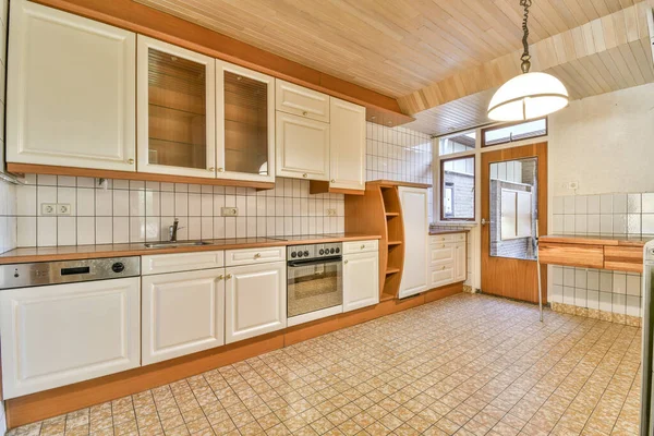 Uma Cozinha Com Piso Azulejo Armários Brancos Parede Acima Forno — Fotografia de Stock