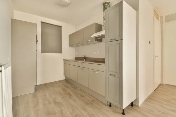 Eine Leere Küche Mit Holzboden Und Weißen Schränken Der Wand — Stockfoto