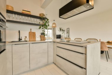 Beyaz döşemeleri ve siyah aletleri olan modern bir mutfak çok temizdir.