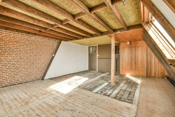 stock image an unfinished room with wood flooring and exposed walls on either side of the room, there is a brick wall that has been