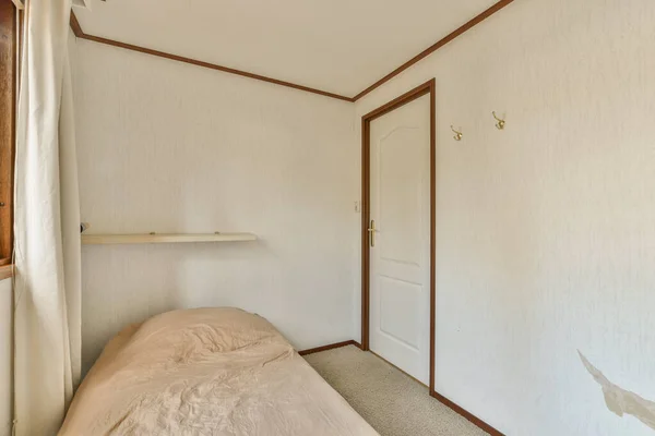 Ein Bett Einem Raum Mit Weißen Wänden Und Holzverkleidungen Der — Stockfoto