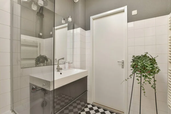 洗面台 シャワーストールの前の床に黒と白のチェックタイルのバスルーム — ストック写真